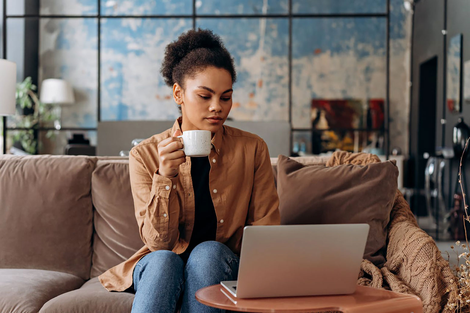 Millennial Woman Searching for a Home on Her Laptop